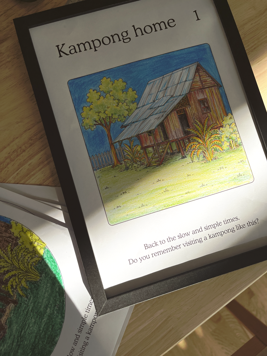 Illustration of a house labeled 'Kampong home' on a book page.